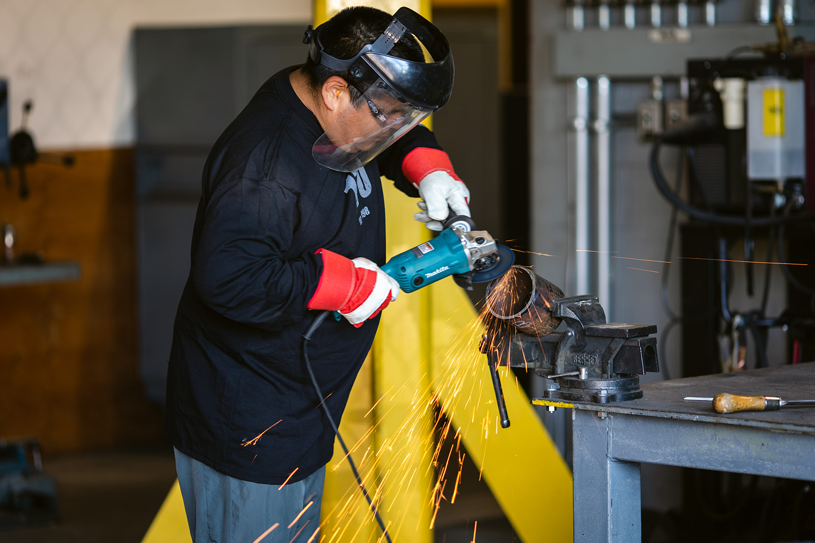 An Indigenous tradeworker working in a shop.