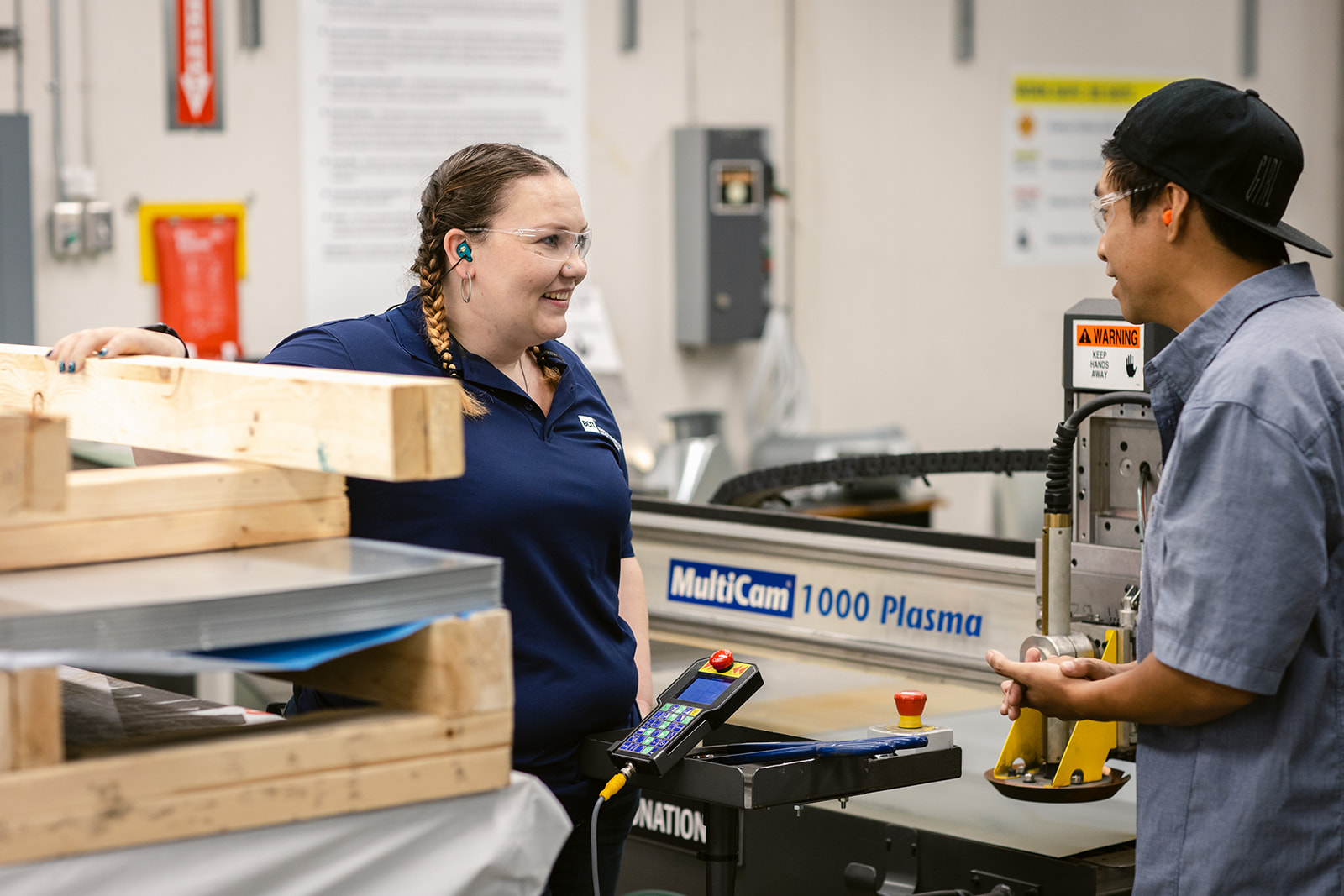 A woman and a man in a workshop looking at each other.